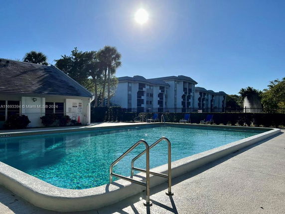 Outdoor view of a swimming pool with surrounding facilities and residential buildings.