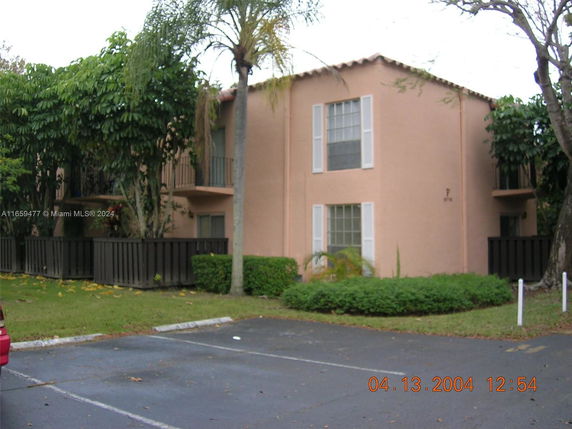 Front view of a two-story building with a plain facade and shuttered windows.