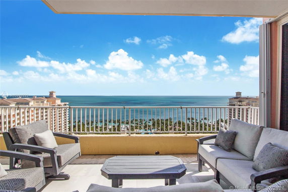 Panoramic view from a balcony overlooking the ocean and adjacent buildings.