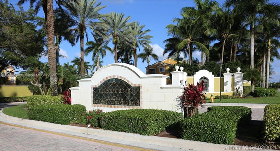 Entrance view of a luxury condominium complex with name signage.