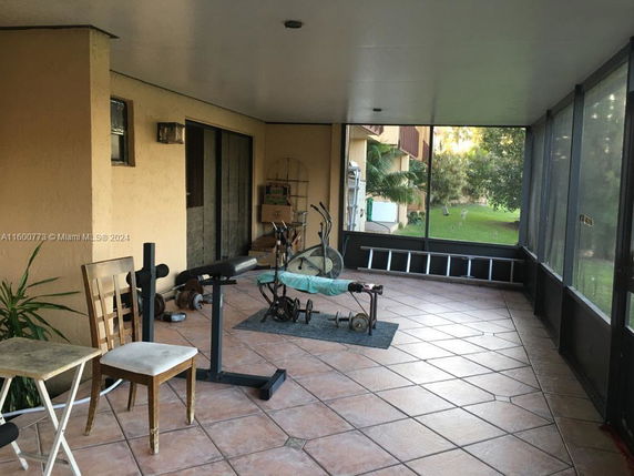 Indoor area with exercise equipment on tiled flooring.