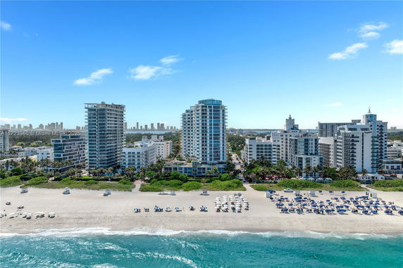 View of beachfront high-rise buildings with sandy beach and ocean.