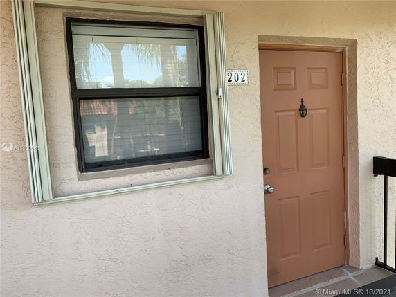 Front view of a building entrance with a window next to a door labeled 202.