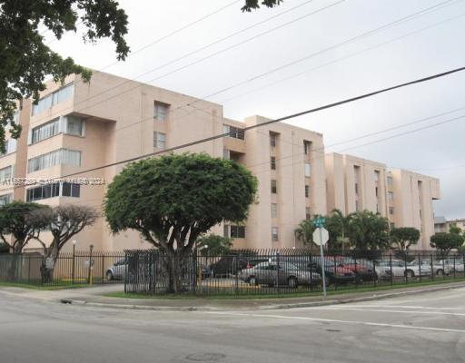 Front view of a multi-story building with parking area.