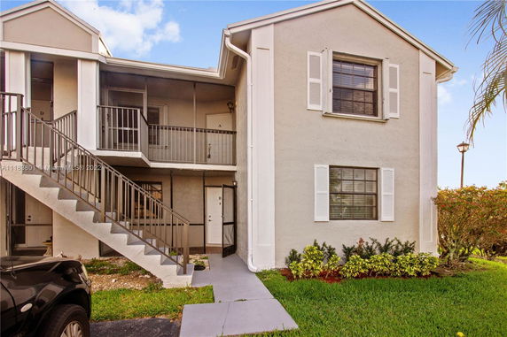 Front view of a two-story apartment building with external stairs.