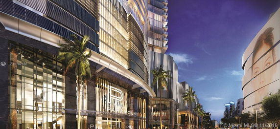 Front view of a modern high-rise building with illuminated facade and large 'P' logo.