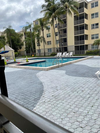 Outdoor area with a swimming pool and tall apartment buildings in the background.