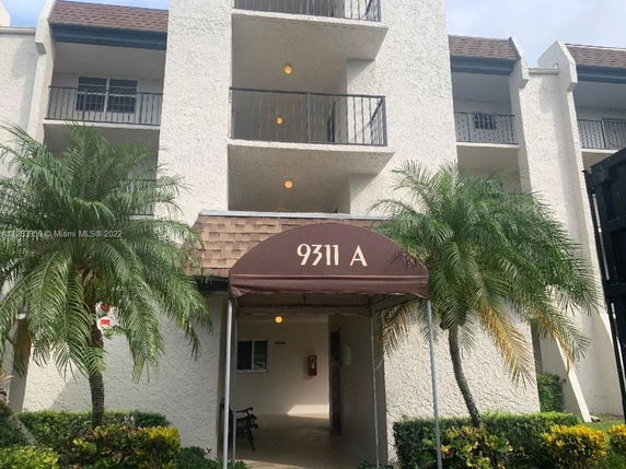 Front view of a multi-story building with a brown canopy entrance.