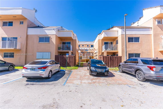 Parking area in front of a multi-story residential building.