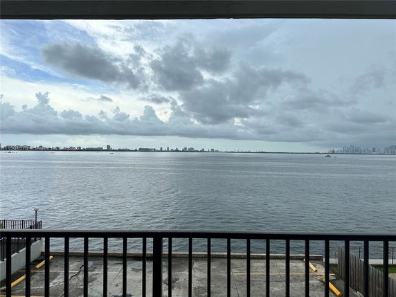 Wide view of a waterfront with city skyline in the distance.