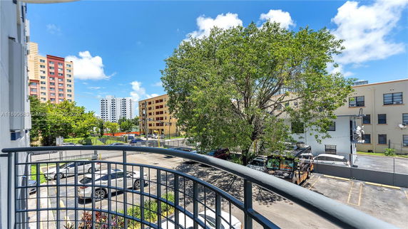 View from balcony showing nearby buildings and parking area.