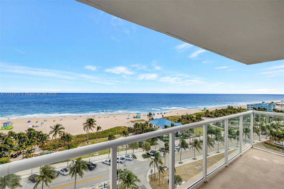 Panoramic view from a balcony overlooking a beach and ocean.