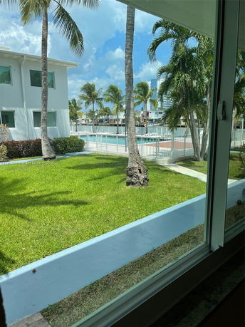 View of a white two-story building next to a swimming pool.