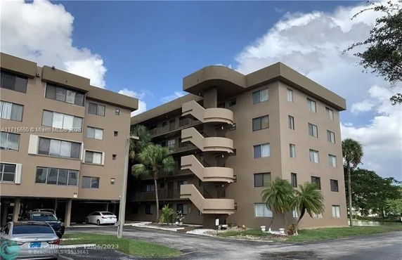 Front view of a multi-story apartment building with external staircases.