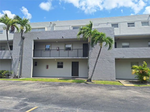 Front view of a multi-story residential building with balconies.
