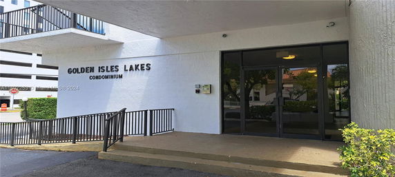 Entrance of Golden Isles Lakes condominium with glass doors and railing.