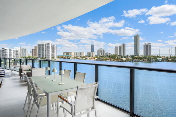 Wide-angle view from a balcony overlooking a city skyline and water body.