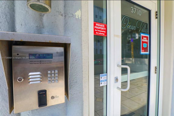 Front view of a building entrance with keypad and security door.