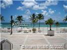 View of a beachfront area with palm trees and ocean in the background.