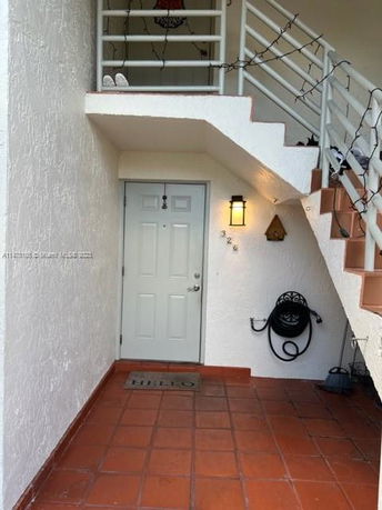 Front view of a staircase and entry door to a residential building.