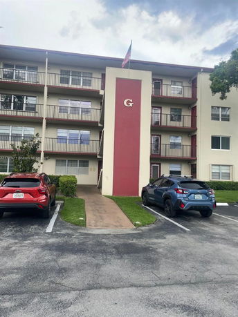 Front view of a four-story apartment building with balconies.