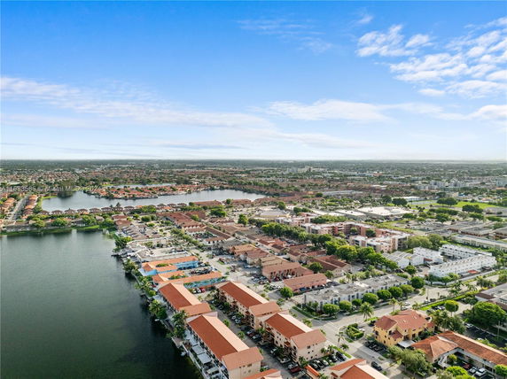 Aerial view of a residential area with multiple buildings and a water body.