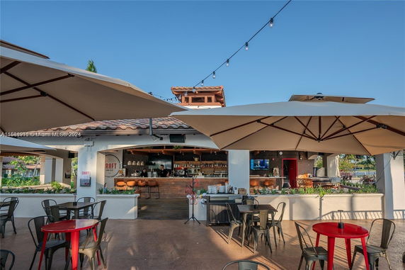 Front view of an outdoor dining area with large umbrellas, tables, and chairs.
