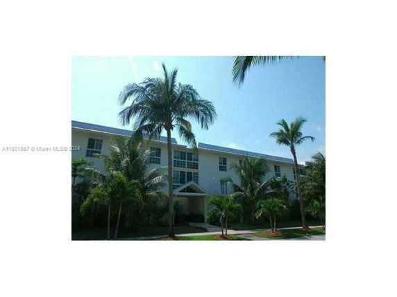 Front view of a multi-story building with palm trees.