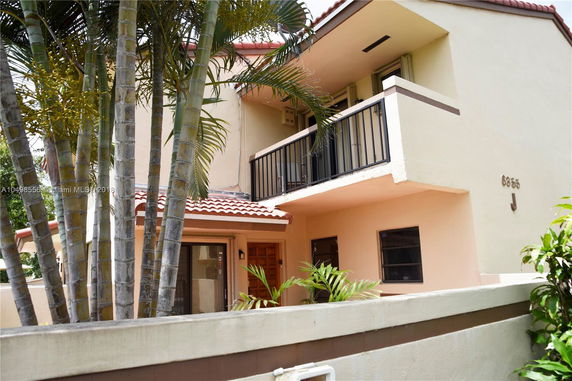 Front view of a two-story house with a balcony and tiled roof.