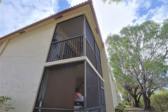 Side view of a multi-story building with screened balconies.