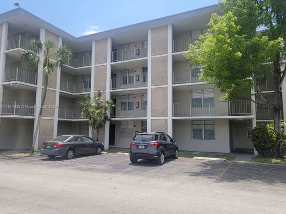 Front view of a multi-story apartment building with balconies.