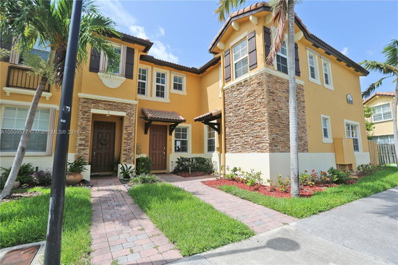Front view of a two-story house with brick and stucco exterior.