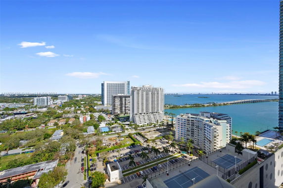 Aerial view of a coastal cityscape with high-rise buildings and a bay.