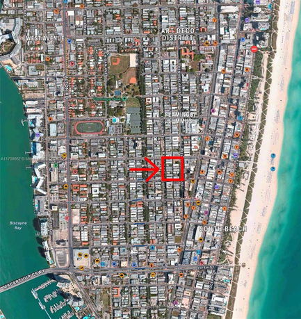 Aerial view of an urban area showing streets, buildings, and a beach on the right side.