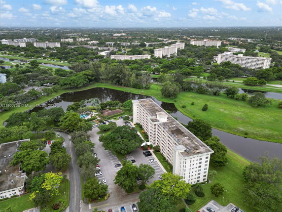 Panoramic view of a large residential complex surrounded by greenery and ponds.