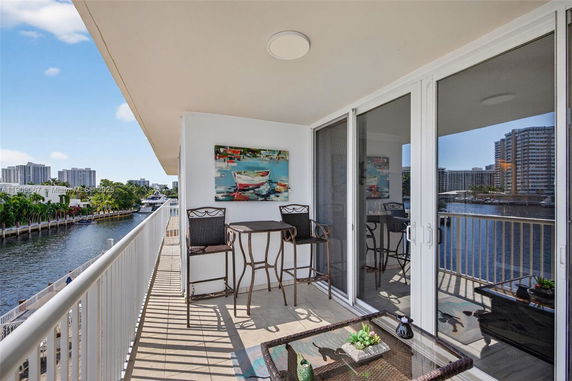 Balcony view from a building overlooking waterway and cityscape.