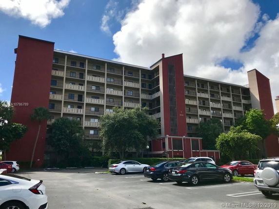 Front view of a multi-story apartment building with balconies.