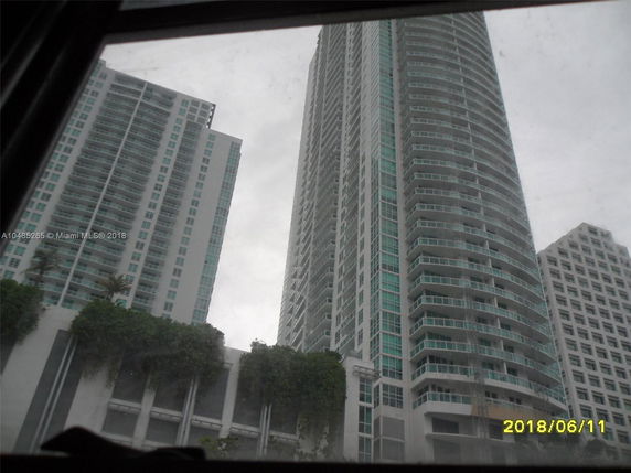 Elevated view of modern high-rise buildings with numerous balconies and a facade of glass and concrete.