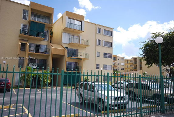 Outdoor parking area in front of a multi-story apartment building.