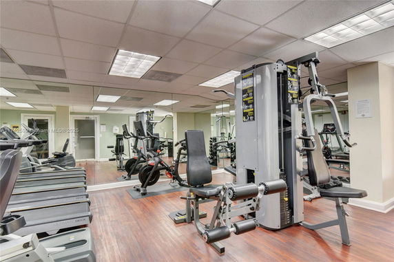 Indoor gym area with exercise equipment and mirrored walls.