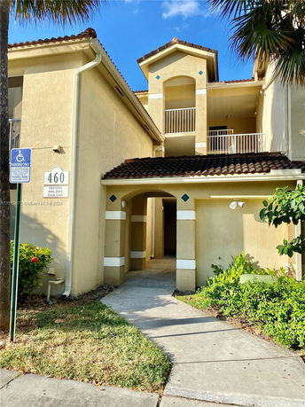 Front view of a multi-story building with a covered entrance and balconies.