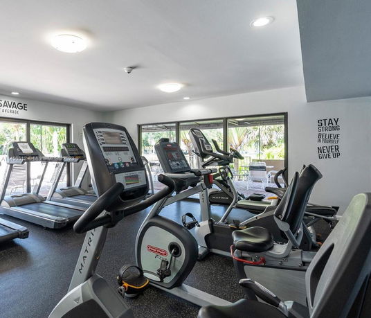 Indoor gym area with exercise equipment including treadmills and stationary bikes.
