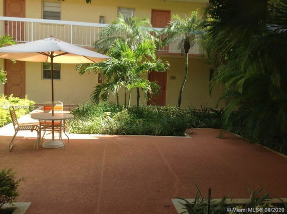 Outdoor courtyard with patio furniture and plants.
