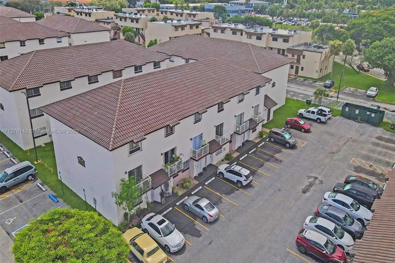 Aerial view of a residential building with adjacent parking area.