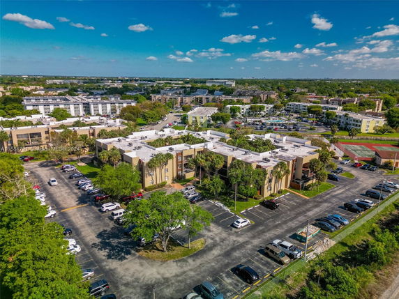 Aerial view of a residential area with multiple apartment buildings and parking spaces.