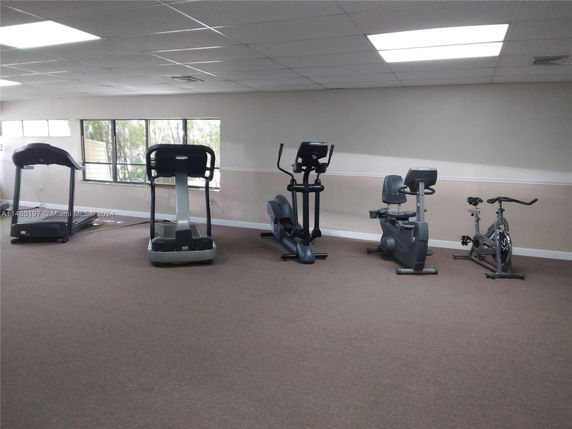 Indoor gym area with exercise equipment including treadmills and stationary bikes.