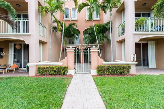 Front view of a multi-story building with balconies and a gated entrance.