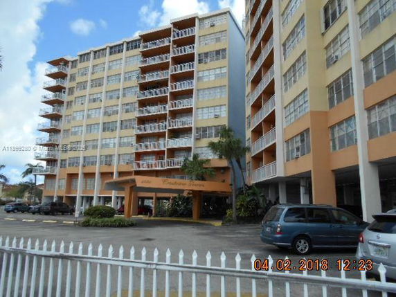 Front view of a multi-story apartment building with balconies.
