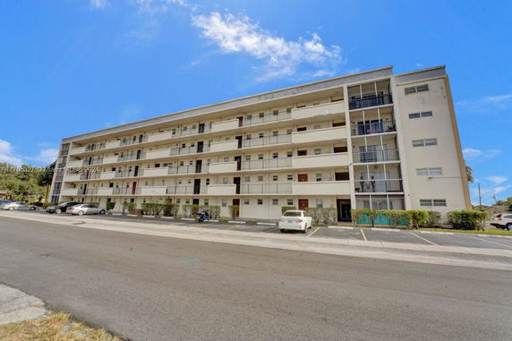 Front view of a multi-story apartment building with balconies.