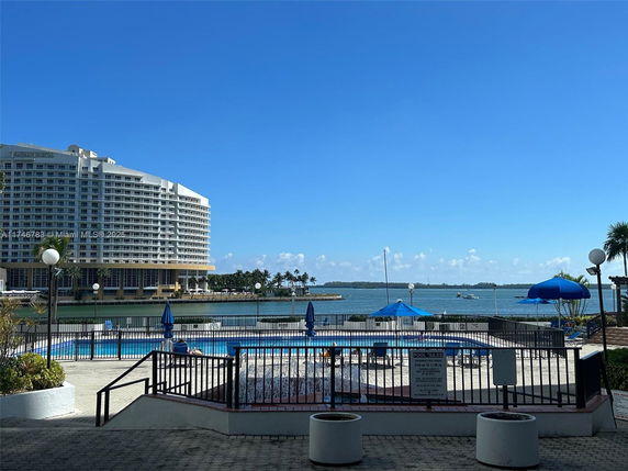 View of a high-rise building with balconies by the waterfront.